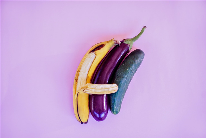 A banana next to an aubergine and courgette