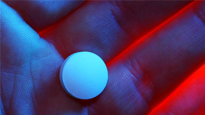 a hand holding an ed pill